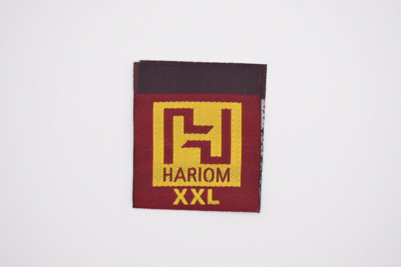 Hariom centre-fold woven brand label: front view, premium woven clothing label sample