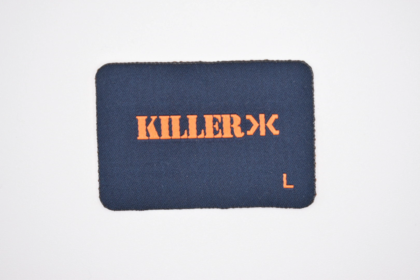 Killerx die-cut woven brand label: front view, custom clothing label sample