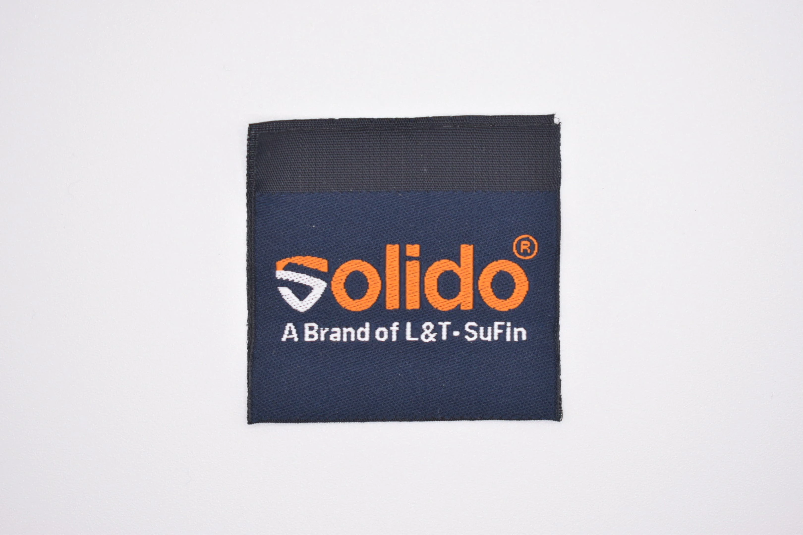 Solido centre-fold woven brand label: front view, premium woven clothing label sample