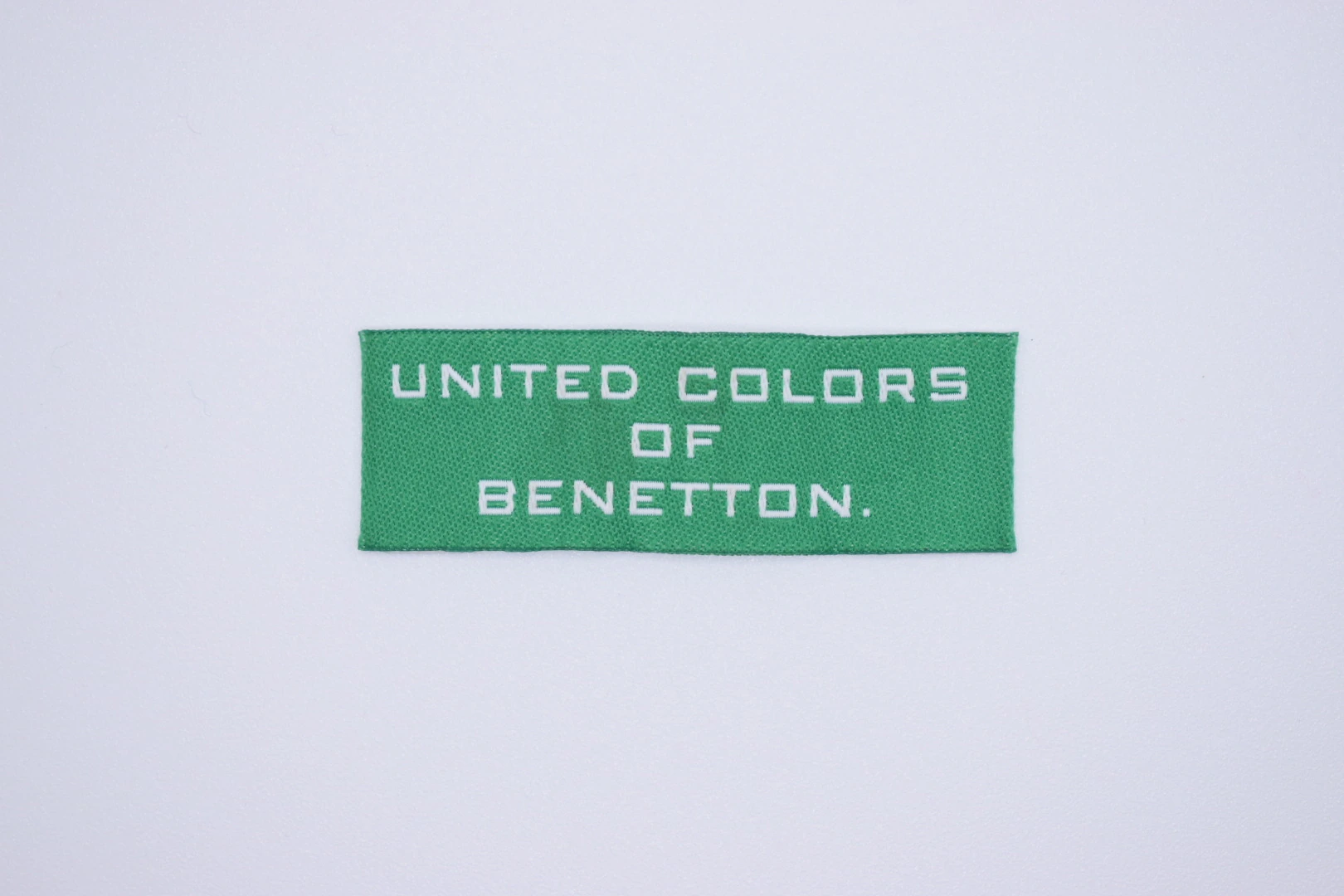 United Color end-fold woven brand label: front view, custom clothing label sample