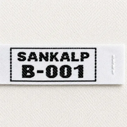 Sankalp B-001 white woven name and number label with bold black framed identifier, uniform identification woven label sample