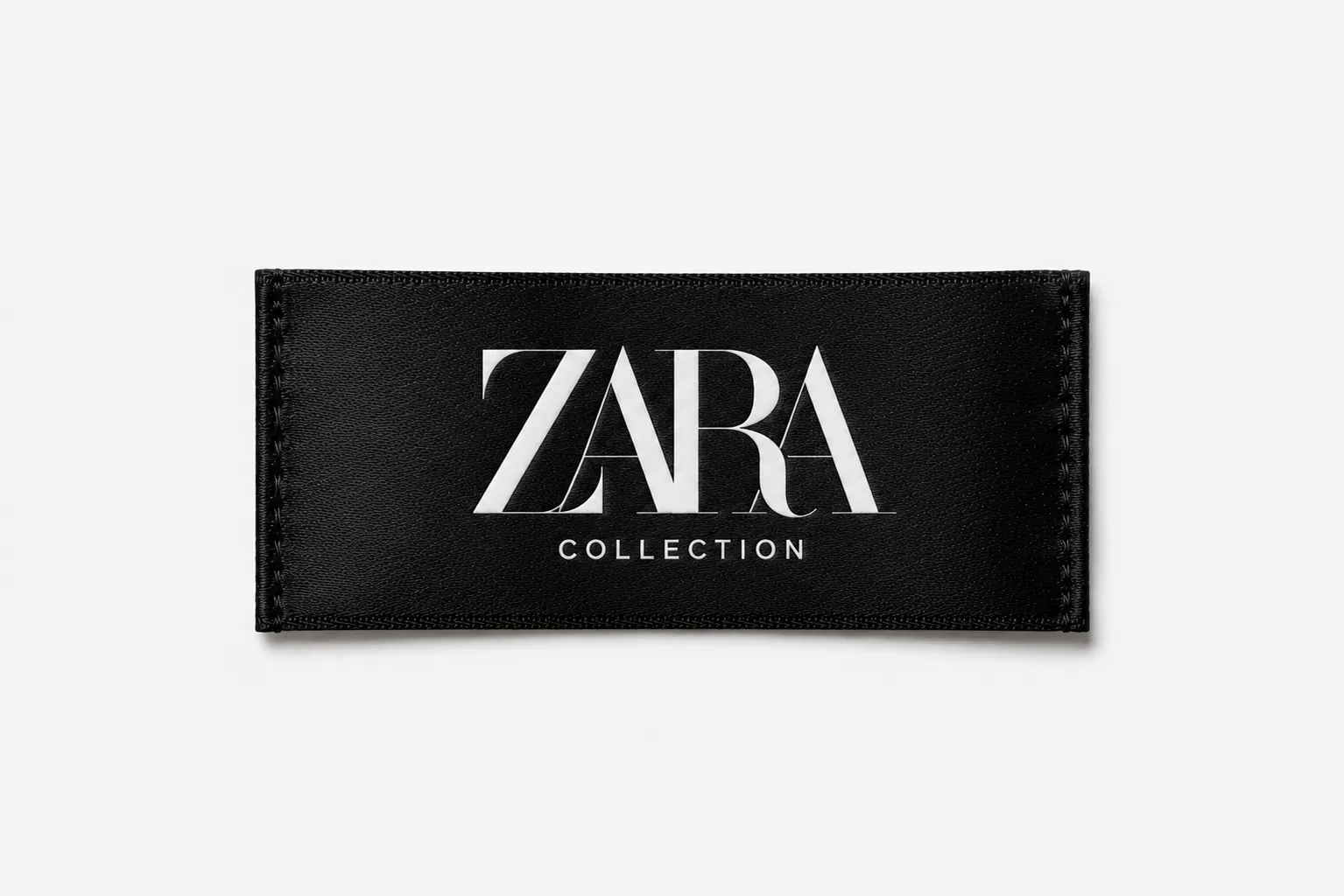 Black satin printed brand label sample with bold white modern-serif wordmark and Collection subtitle — high-street fashion design reference, satin print finish