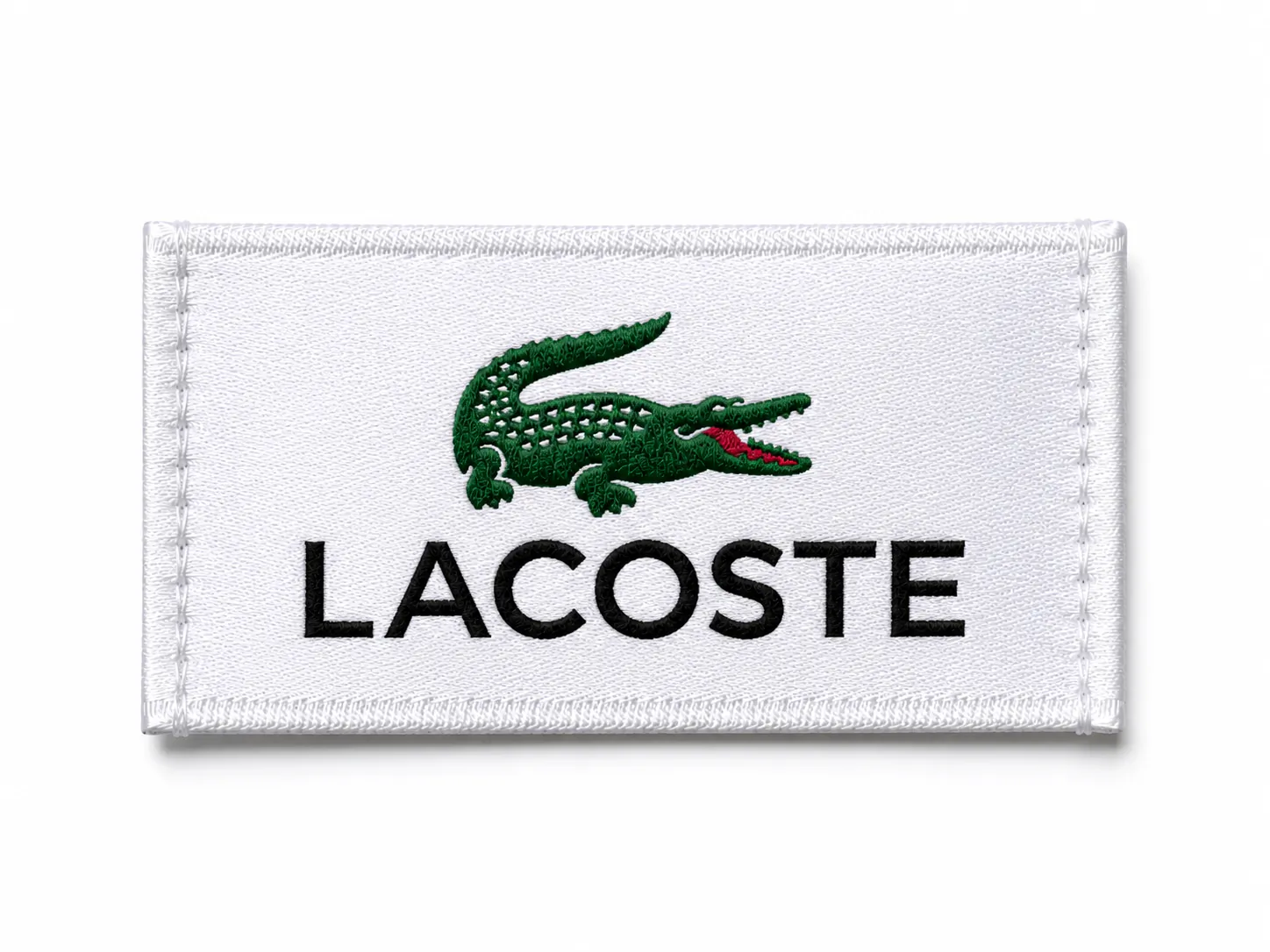 White woven brand patch sample with embroidered green reptile icon and bold black sans-serif wordmark — premium sportswear design reference, embroidered patch finish